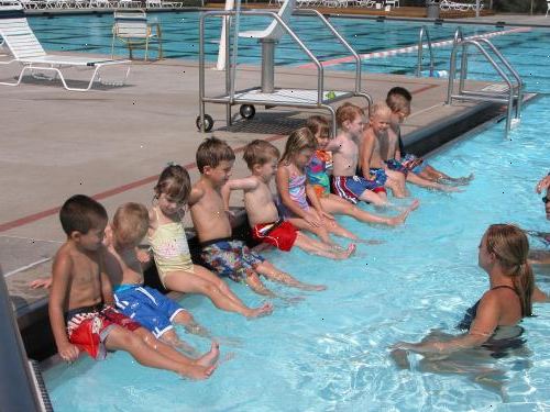 Hvordan underviser svømme lektioner. Har eleven sidder på kanten af poolen og se på, mens du viser dem, hvordan man udføre visse slag, og hvordan til at flyde.